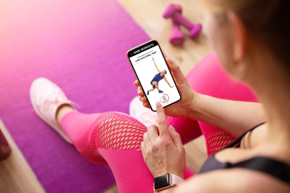 woman-uses-fitness-app-her-phone-working-out-home.jpg