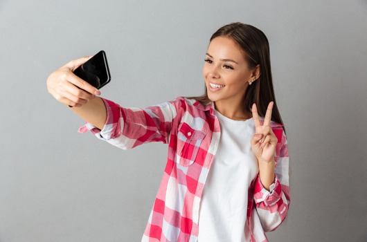 photo-joyful-young-woman-checkered-shirt-taking-selfie-by-her-phones.jpg
