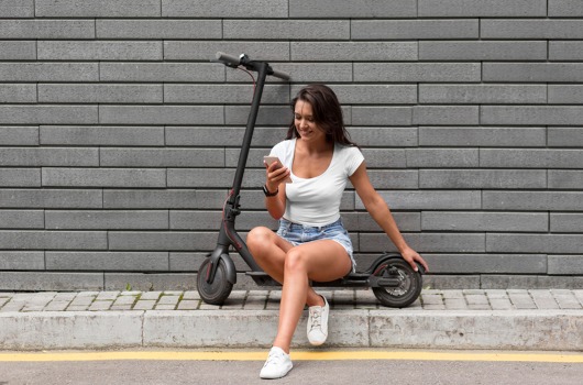 woman-checking-her-phone-while-sitting-scooter.jpg